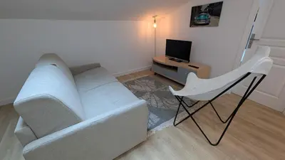 a living room with a white couch and a television at La Fontaine in Cannes