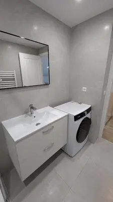 a bathroom with a sink and a washing machine at La Fontaine in Cannes