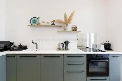 a white kitchen with a sink and a stove at August in Cannes