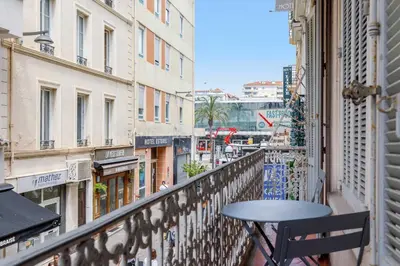 a table on a balcony with a view of a city at August in Cannes