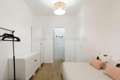 a white bedroom with a bed and a closet at August in Cannes