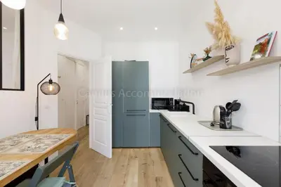 a kitchen with white counters and a blue refrigerator at August in Cannes
