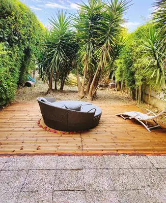 a bath tub sitting on top of a wooden deck at Garden Flat in Cannes in Cannes