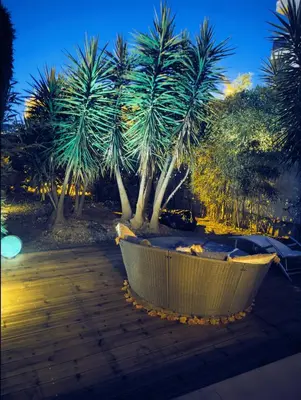 a bath tub sitting next to two palm trees at Garden Flat in Cannes in Cannes
