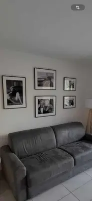 a bed in a room with two pictures on the wall at 2 pièces terrasse piscine Cannes Californie in Cannes