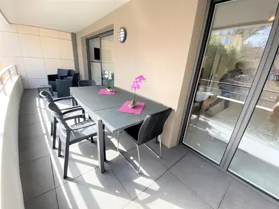 a kitchen and living room with a couch and a table at 2 pièces terrasse piscine Cannes Californie in Cannes