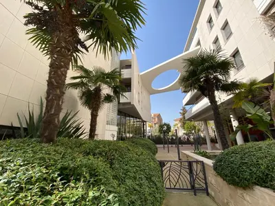 a leather couch in a living room with pictures on the wall at 2 pièces terrasse piscine Cannes Californie in Cannes