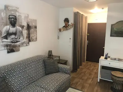 a living room with a couch and a sign on the wall at ORION in Cannes