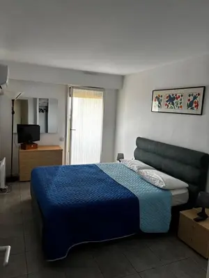a bedroom with a blue bed and a television at Appartamento in riva al mare a Cannes in Cannes