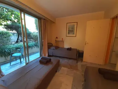 a living room with a couch and a large window at Le Renoir in Cannes