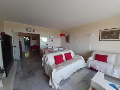 a kitchen with white cabinets and a black microwave at Le Renoir in Cannes