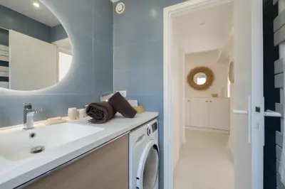 a bathroom with a sink and a washing machine at Stylish 2-Br Apartment Steps from the Croisette in Cannes