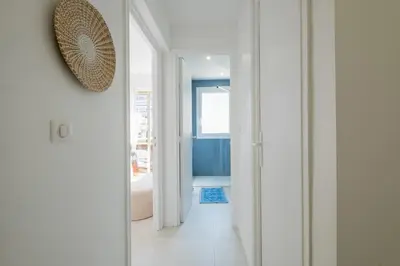 a white hallway with a doorway to a bathroom at Stylish 2-Br Apartment Steps from the Croisette in Cannes