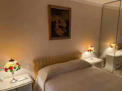 a bedroom with a bed and two tables with lamps at Chez Babette in Cannes