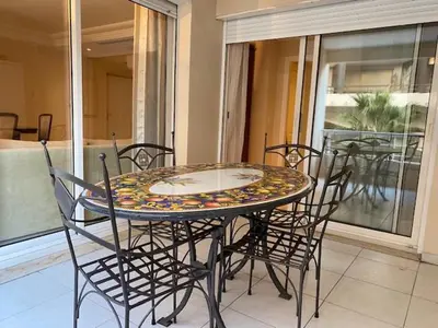 a glass table and chairs on a balcony with a table and chairsktop at Chez Babette in Cannes