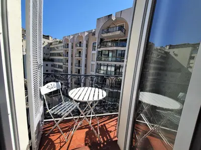 a balcony with chairs and tables on a building at Carré d'or Duplex, by Welcome to Cannes in Cannes