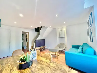 a living room with a blue couch and a table at Carré d'or Duplex, by Welcome to Cannes in Cannes