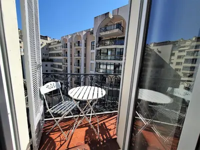 a balcony with two chairs and a table on a building at Carré d'or Duplex, by Welcome to Cannes in Cannes