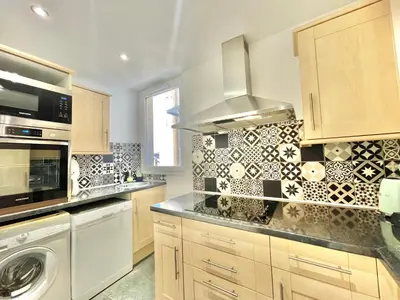 a kitchen with a stove top oven next to a microwave at Carré d'or Duplex, by Welcome to Cannes in Cannes
