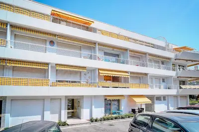 an apartment building with balconies and cars parked in a parking lot at IMMOGROOM - Pool - Terrace - Parking - Air conditioning - NO WIFI in Cannes