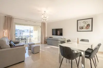 a living room with a table and a dining room at Le Parisien by Winsome Destination in Cannes