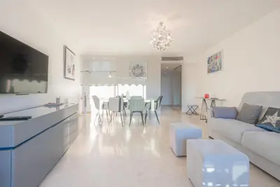 a white living room with a couch and a table at Le Parisien by Winsome Destination in Cannes