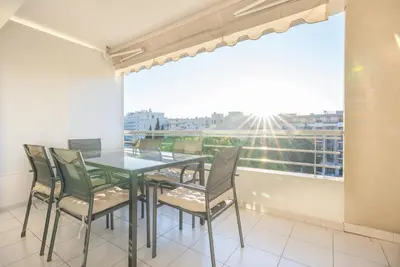 a dining room with a table and chairs and a window at Le Parisien by Winsome Destination in Cannes