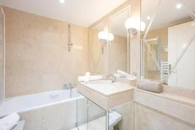 a bathroom with a sink and a tub and a mirror at Le Parisien by Winsome Destination in Cannes