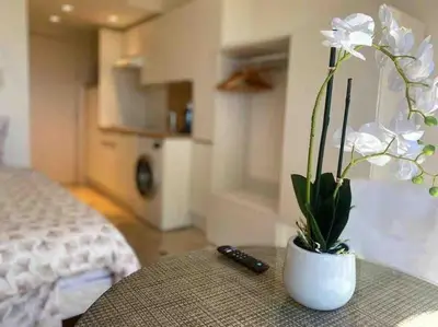 a white vase with a plant on a table in a room at The Sun Paradise Dream in Cannes