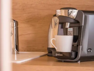 a coffee maker with a coffee cup on a counter at The Sun Paradise Dream in Cannes
