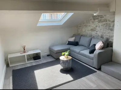 a living room with a couch and a table at Mansarde Cannes in Cannes