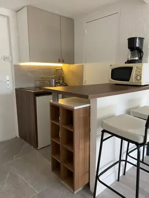 a kitchen with a counter with a microwave and a stool at Mansarde Cannes in Cannes