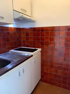 a kitchen with red tiles on the wall at Cannes center parking very calm California neighborhood in Cannes