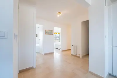 an empty room with white walls and wooden floors at 3-Br apartment near downtown Cannes Sea view parking in Cannes