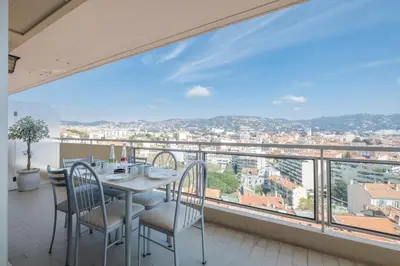 a dining room with a table and chairs and a large window at 3-Br apartment near downtown Cannes Sea view parking in Cannes