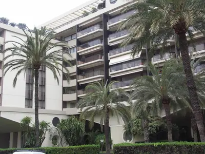 an apartment building with palm trees in front at jardins croisette PRES CROISETTE in Cannes
