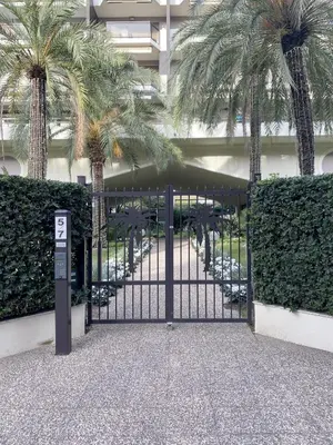 a gate with palm trees in front of a building at jardins croisette PRES CROISETTE in Cannes