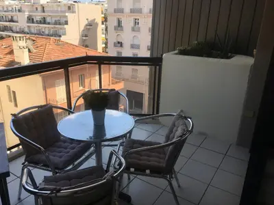 a table and two chairs on a balcony with a view at jardins croisette PRES CROISETTE in Cannes