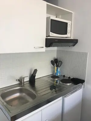 a kitchen with a sink and a microwave at Cannes center terrace AC Wifi 200 m from sea behind Martinez in Cannes