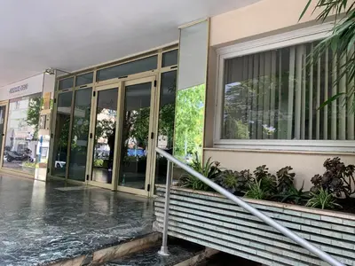 a building with glass doors on a rainy street at Cannes center terrace AC Wifi 200 m from sea behind Martinez in Cannes