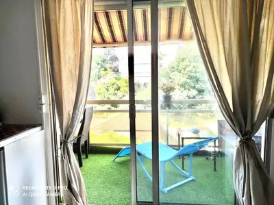 a room with a blue chair in front of a window at Luxurious Studio in Cannes 450m from sea with Terrace and Air Conditioning and private Parking in Cannes