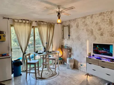 a living room with a table and chairs and a tv at Luxurious Studio in Cannes 450m from sea with Terrace and Air Conditioning and private Parking in Cannes