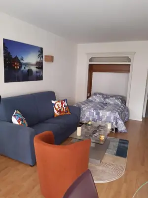 a living room with a blue couch and a bed at SPACIEUX STUDIO 37m2 - Terrasse VUE MER in Cannes