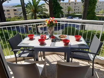 a blue table with a vase of flowers on a balcony at SPACIEUX STUDIO 37m2 - Terrasse VUE MER in Cannes