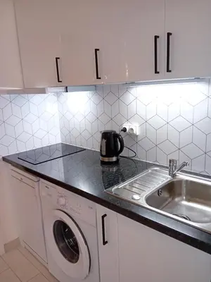 a kitchen with a washing machine and a sink at SPACIEUX STUDIO 37m2 - Terrasse VUE MER in Cannes