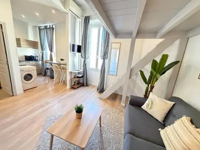 a living room with a couch and a table at Beautiful studio Cannes Center in Cannes