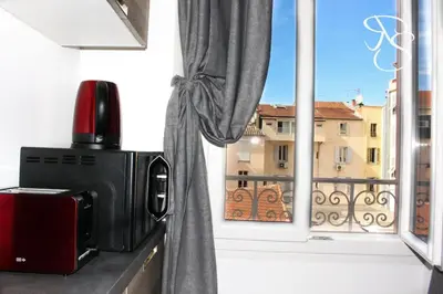 a microwave and a window with a view of a building at Beautiful studio Cannes Center in Cannes