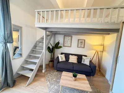 a living room with a blue couch and a loft bed at Beautiful studio Cannes Center in Cannes
