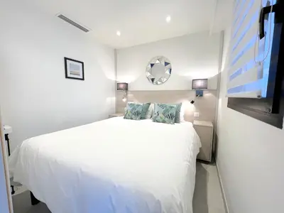 a white bedroom with a white bed and a mirror at Marema appartement, by Welcome to Cannes in Cannes