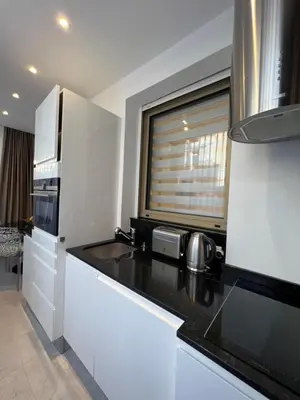 a kitchen with white cabinets and a black counter top at Marema appartement, by Welcome to Cannes in Cannes